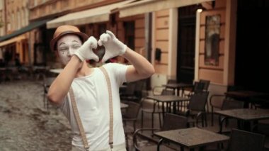 Gösterici elleriyle, gülümsemesiyle, el sallayarak, flört ederek kalbini gösterir..