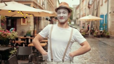 Sanatçı sağa sola bakıyor. İnsanları kollarıyla selamlıyor..