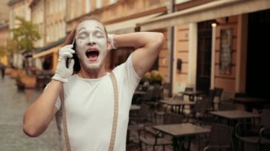 Yakışıklı şovmen telefonda mutlu bir yüz ifadesiyle konuşuyor..