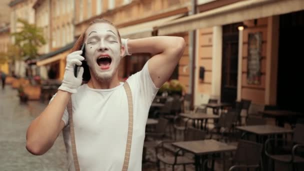 Guapo animador está hablando por teléfono con feliz expresión facial . — Vídeo de stock