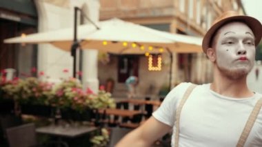 Genç yakışıklı pandomimci kafenin yakınındaki sokakta gösteri yapıyor, inkar ediyor, kesinlikle hayır diyor..