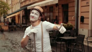 Pandomimci birini selamlar, gülümser, el sallar, neşeli, gururlu bir bakışla flört eder..