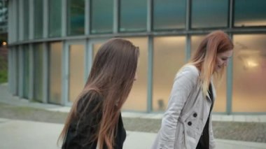 İki çekici kız, onları merdivenlerde taşımak için bavullarını alıyorlar..