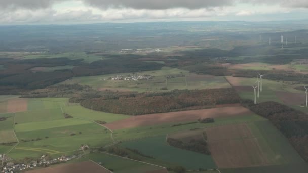 Espectacular vista desde plano sobre tierra con minúsculas casas, campos, molinos de viento, bosques . — Vídeo de stock