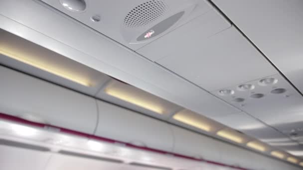 Ceiling of airplane cabin with load speaker, no smoking sign, buttons. — Stock Video