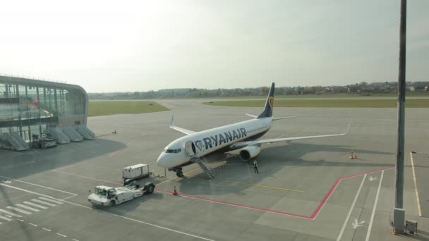 Boarding of plane has finished. One worker stands on runway near vehicle. — Stock Video