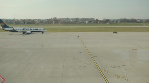 Plane of Ryanair Airlines ready to take off on runway, security car rides ahead. — Stock Video