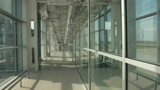 Snygg glaskorridor i flygplatsterminal till landningsbana med flygplan. — Stockvideo