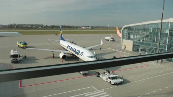 Samolot linii lotniczych Ryanair na lotnisku, widok z terminalu przez okno. — Wideo stockowe