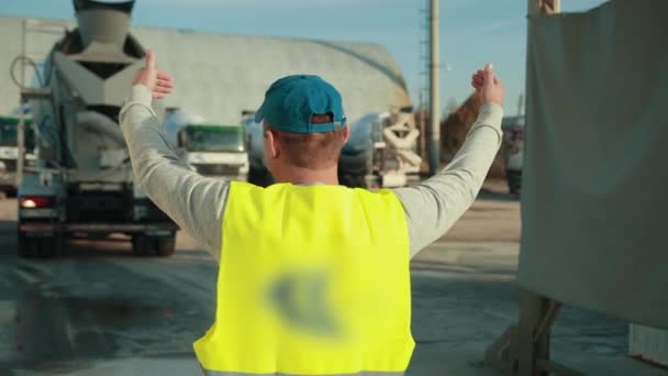El trabajador se hace cargo del lugar e instruye al conductor del camión . — Vídeos de Stock