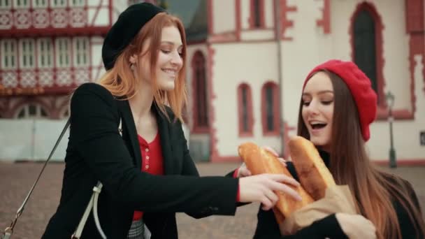 Twee mooie Franse meisjes in zwarte jassen en baretten vechten vrolijk — Stockvideo