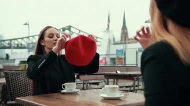 İki güzel baştan çıkarıcı kadın sokakta oturup kahve içiyorlar.