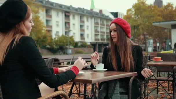 Duas belas mulheres sedutoras francês sentar na rua e beber café — Vídeo de Stock