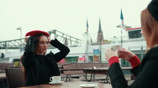 Dvě krásné svůdné ženy Francouzky sedět na ulici a pít kávu — Stock video