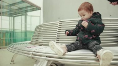 Bir erkek, kadın şapkası giyer. Bir çocuk başlığını atar.