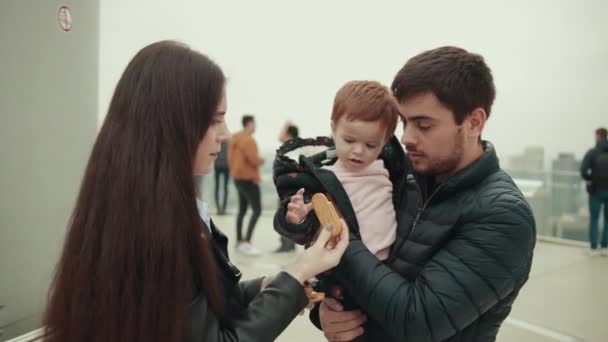 Papà e mamma sono felici con la loro figlia. Una donna dà da mangiare un pan di zenzero . — Video Stock