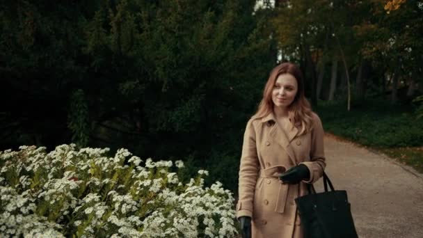 Vrouw met bruin haar, het dragen van jas neemt smartphone uit haar tas gesprekken op de telefoon — Stockvideo