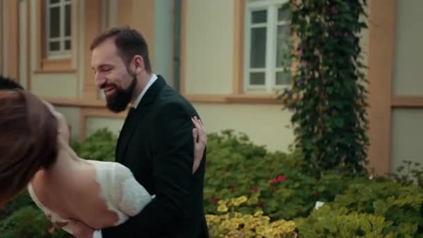 Paar in liefde pasgetrouwd.bruid in trouwjurk zet haar handen op bruidegoms borst — Stockvideo