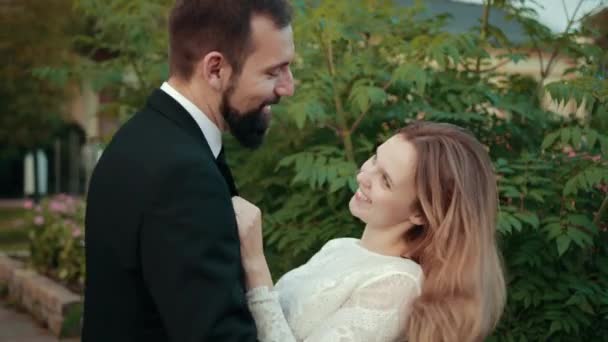 Couple amoureux newlyweds.Bride en robe de mariée met ses mains sur la poitrine des mariés — Video