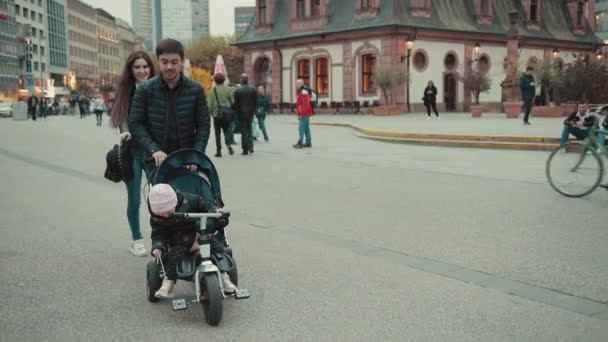 Heureuse femme tenant sa main de maris qui porte une petite fille à vélo . — Video