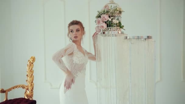 Zbliżenie blondynka panna młoda w biały suknia ślubna pozowanie dla kamery — Wideo stockowe