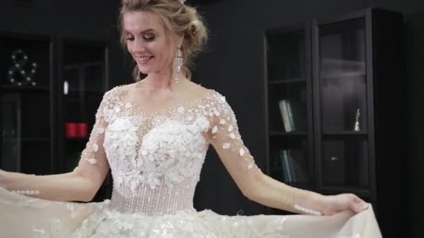 Блондинка невеста в белом свадебном платье с короной на голове идет вперед — стоковое видео