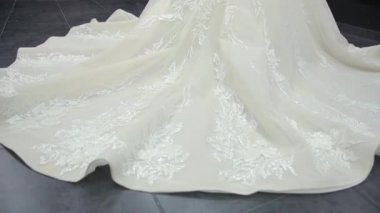 Panorama from large white wedding dress that drags across floor to bride walking