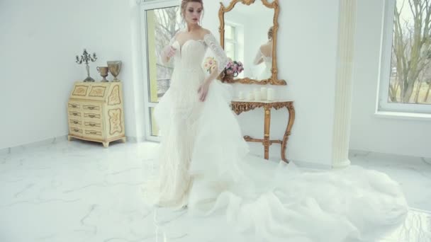 Young blonde bride in white wedding dress poses in front of camera, turns — Stock Video