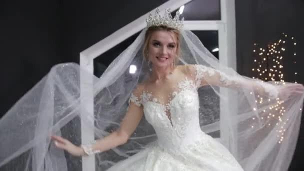 Young bride with crown on head posing in front of camera turns left to right. — Stock Video