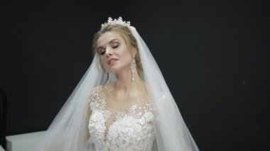 Young beautiful bride in white wedding dress plays with veil making waves
