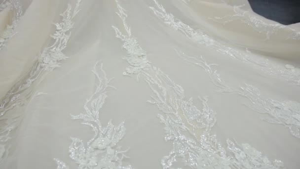 Panorama van grote witte trouwjurk die over vloer naar bruid loopt — Stockvideo
