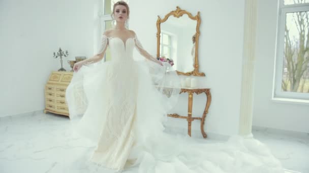 Young blonde bride in white wedding dress poses in front of camera, turns — Stock Video