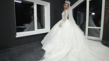 bride crown on head chic magnificent white wedding dress that drags on ground.