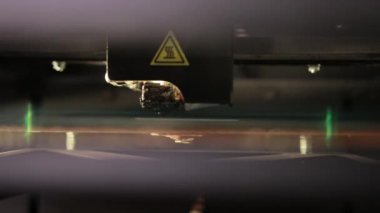 3D technology close up of the printer head printing a plastic part product.
