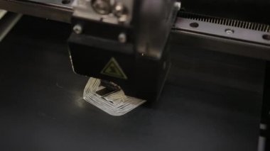 3D technology close up of the printer head printing a plastic part product.