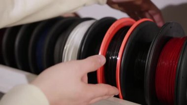 mens hand takes a spool plastic calves wire for printing 3D printer technology