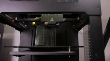 3D technology close up of the printer head printing a plastic part product.