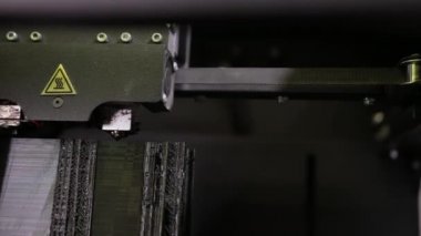 3D technology close up of the printer head printing a plastic part product.
