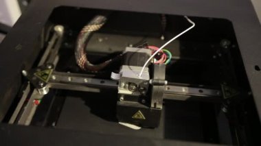 3D technology close up of the printer head printing a plastic part product.