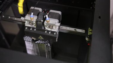 3D technology close up of the printer head printing a plastic part product.