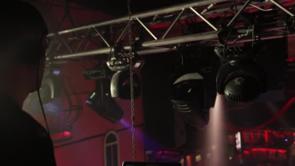DJ in einem Nachtclub arbeitet, mischt Musik mit einer Fernbedienung. — Stockvideo
