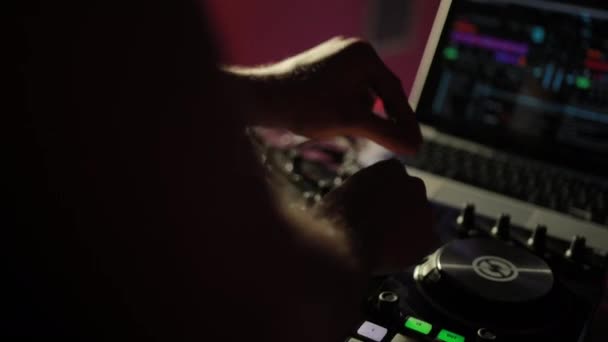 DJ dans une boîte de nuit fonctionne, mélange la musique avec une télécommande . — Video