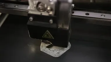 3D technology close up of the printer head printing a plastic part product.