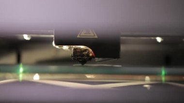 3D technology close up of the printer head printing a plastic part product.