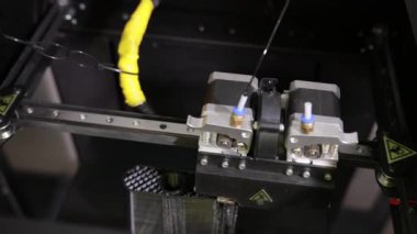 3D technology close up of the printer head printing a plastic part product.