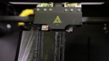 3D technology close up of the printer head printing a plastic part product.