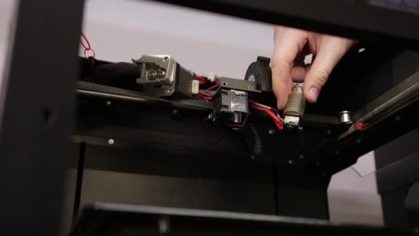 Jonge man reparaties 3d printer reparaties de details van debugging werk. — Stockvideo