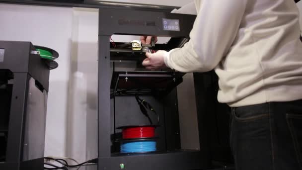 Jonge man reparaties 3d printer reparaties de details van debugging werk. — Stockvideo