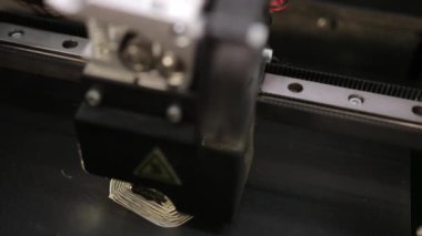 3D technology close up of the printer head printing a plastic part product.
