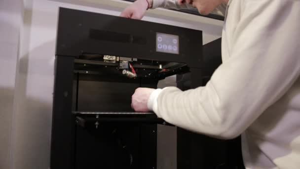 Jonge man reparaties 3d printer reparaties de details van debugging werk. — Stockvideo